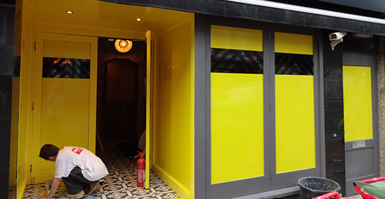 Yellow vinyl applied to windows of nightclub with black chevrons.