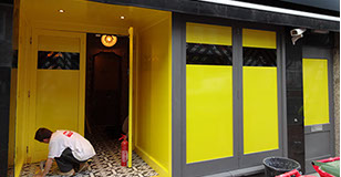 Yellow vinyl applied to windows of nightclub with black chevrons.